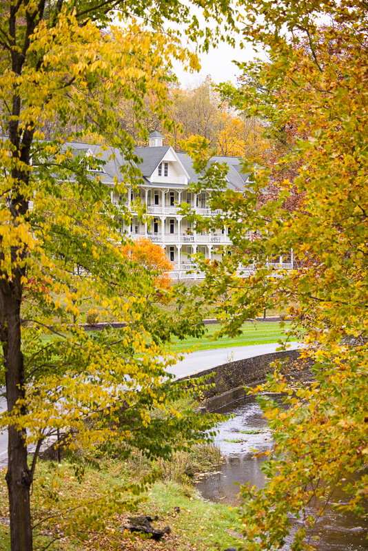 vibrant, colorful image of omni bedford springs peeking through the fall foliage located in Bedford springs at this luxurious wedding venue 