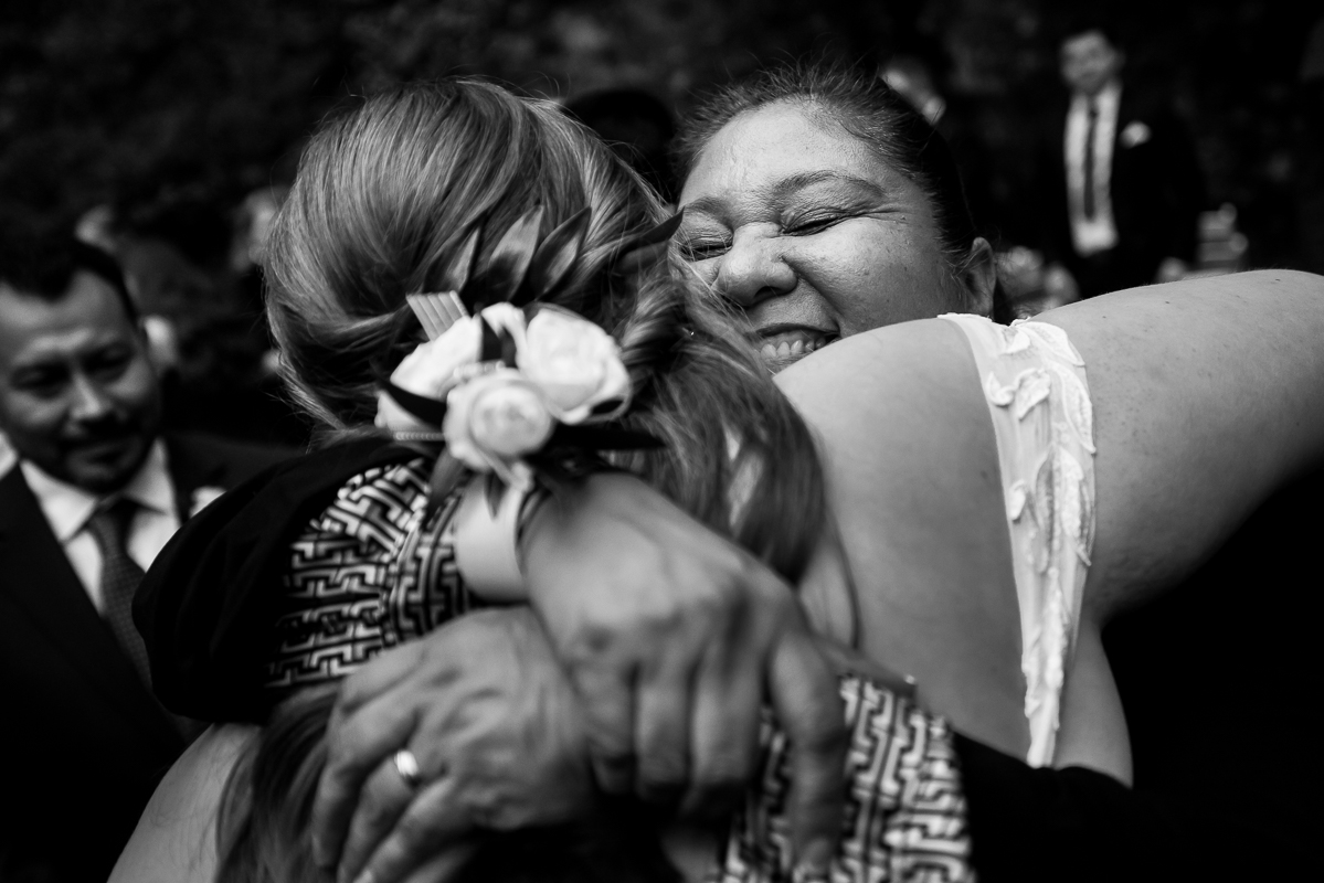 candid, authentic, emotional moment between the bride and her mother in law as they hug each other with big smiles after this outdoor fall wedding ceremony at the omni bedford springs in Bedford pa 
