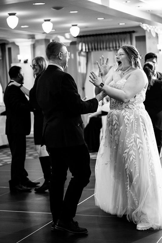 candid, fun black and white image of the bride and her dad as they share a dance together during this omni bedford springs wedding reception 