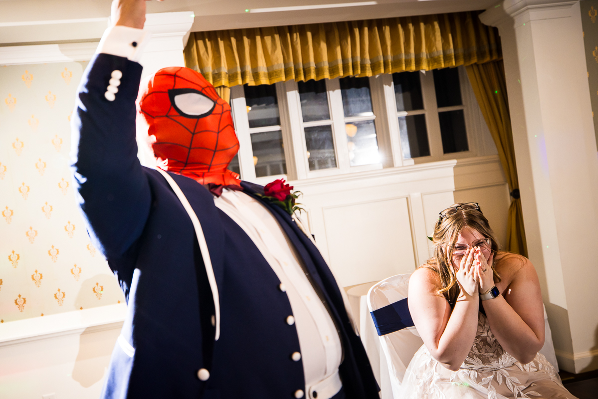 best pa wedding photographer, lisa rhinehart, captures this unique fun image of the groom as he shows guests his spiderman mask during this wedding reception in pa 