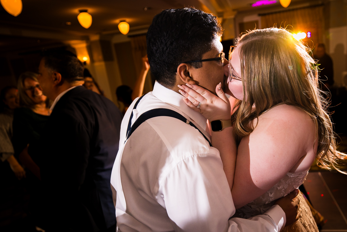 creative Omni wedding photographer, lisa rhinehart, captures this end of the night shot of the bride and groom as they share a kiss together on the dance floor at the end of their wedding reception at the omni bedford springs resort in Bedford pa 