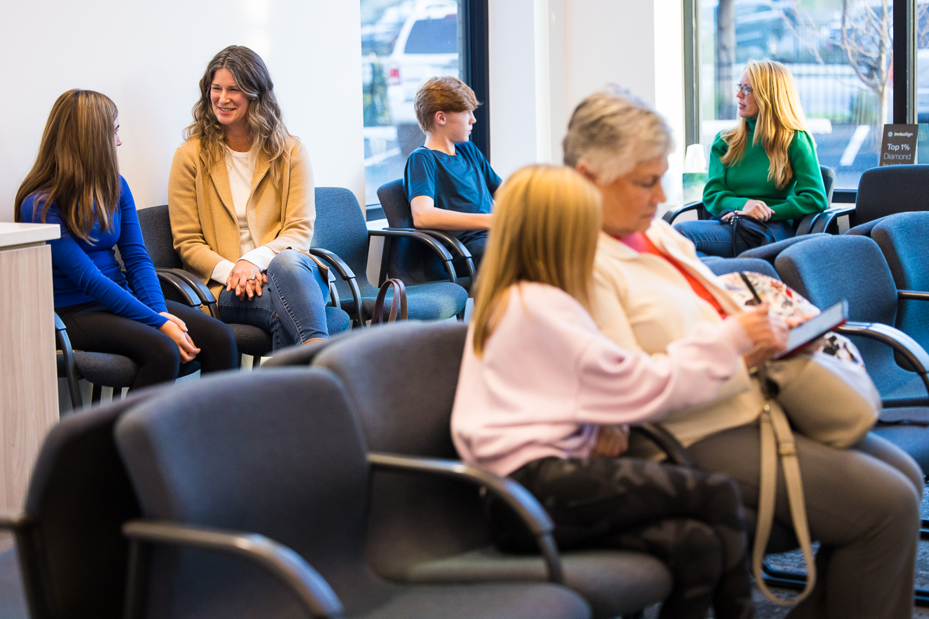 candid image of patients and their parents as they sit in the waiting room of the newly renovated west chester orthodontics building as part of this business branding photography session