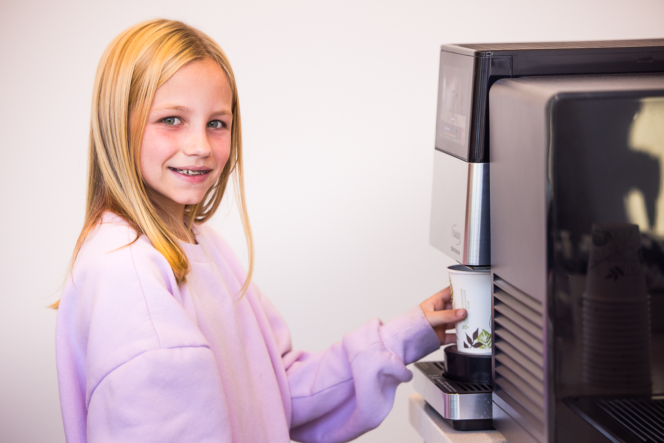 pa commerical photographer, Lisa rhinehart, captures this image of a young girl getting a drink out of the machine at west chester orthodontics in pa 
