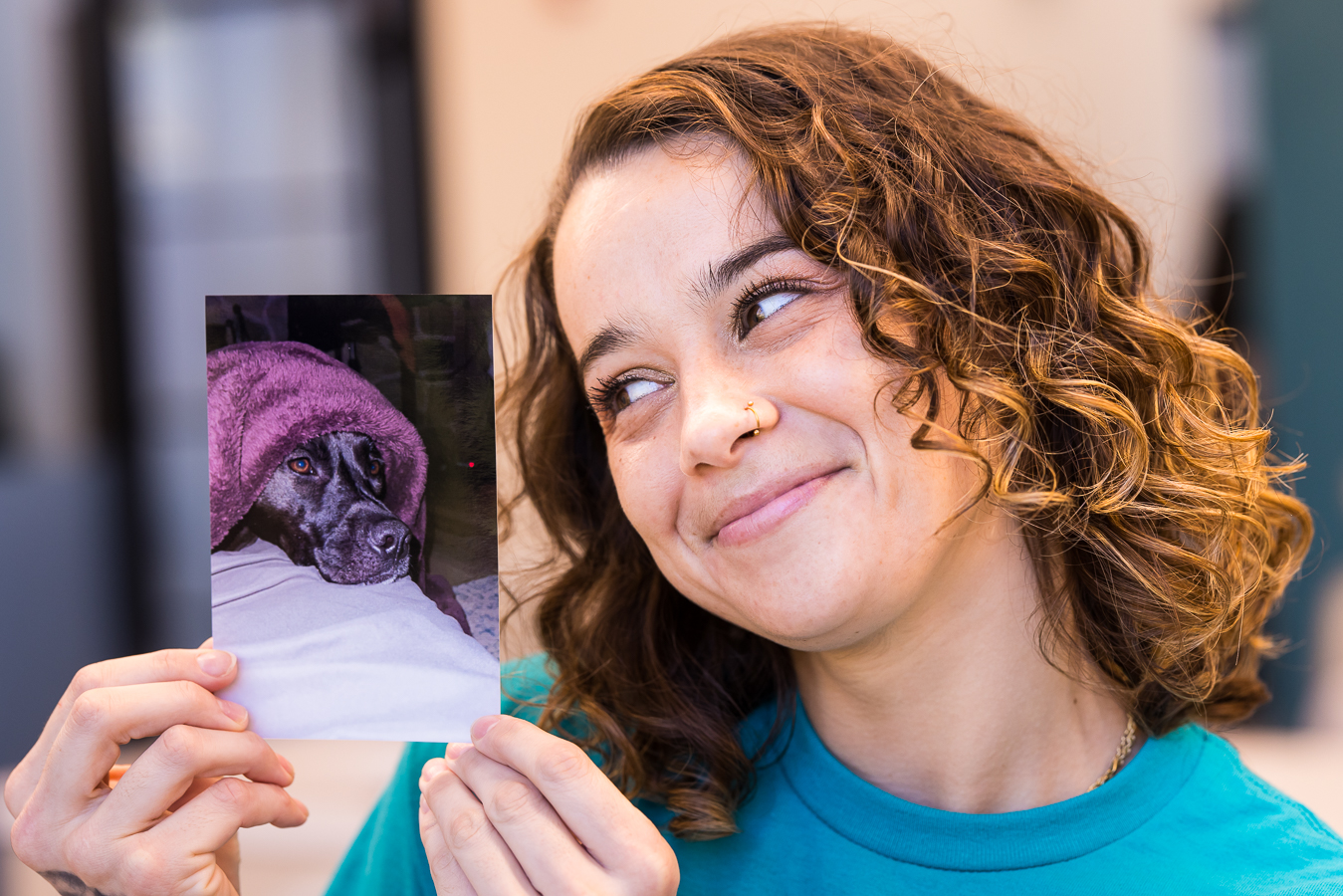lisa rhinehart, social media photographer, captures this image of a dental assistant as she holds up a picture of her dog and smiles at it during her Social media content session 