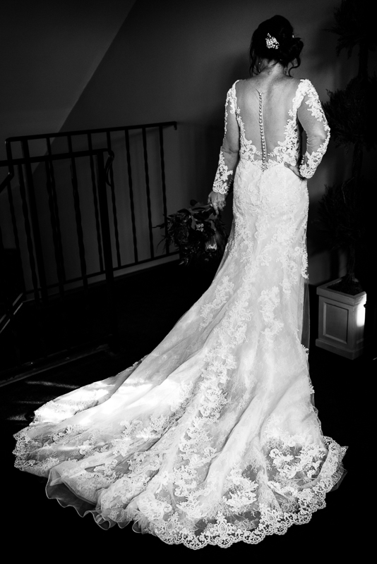 pa wedding photographer, lisa rhinehart, captures this black and white image of the back of the bride's dress before their wedding ceremony at stroudsmoor country inn 