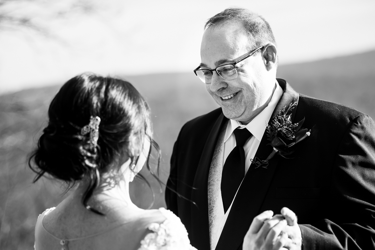 candid black and white image of the bride and groom as they look at one another for the first time during their first look located at ridgecrest at stroudsmoor country inn before their outdoor Christmas winter wedding ceremony in pa 