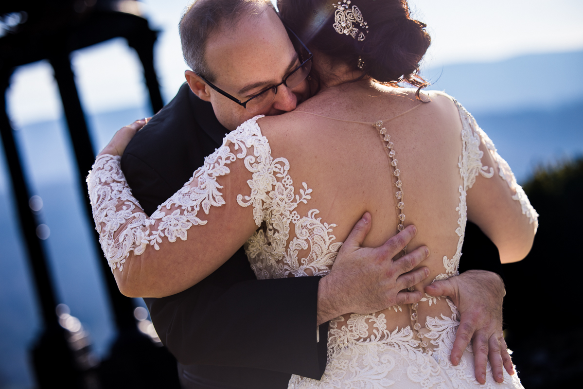 candid wedding photographer, lisa rhinehart, captures this authentic emotionally moment of the bride and groom as they share a hug during their first look at ridgecrest at the stroudsmoor country inn in pa