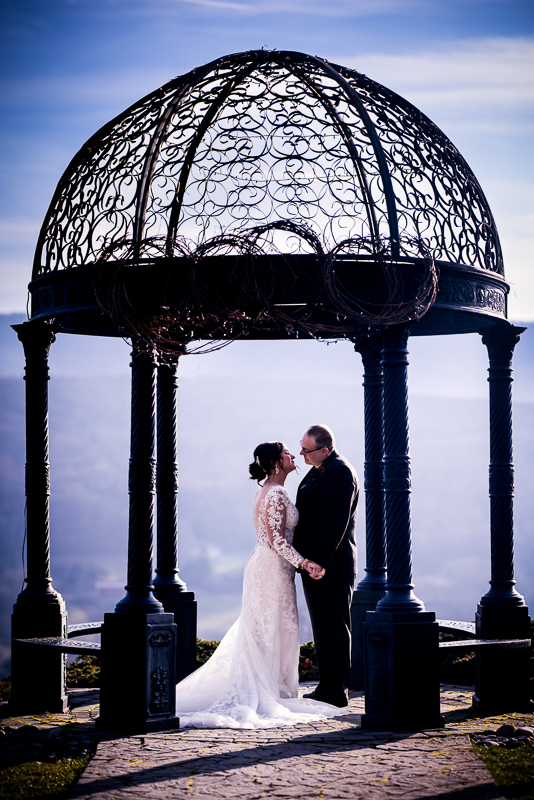 stroudsmoor country inn wedding photographer, lisa rhinehart, captures this romantic portrait between the bride and groom as they stand underneath the dome structure located on ridgecrest at stroudsmoor country inn surrounded by the mountains 