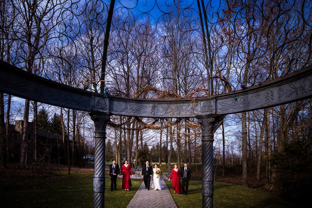 creative wedding photographer, lisa rhinehart, captures this unique angle of the bride and groom as they walk with their wedding party at ridgecrest located at the stroudsmoor country inn in pa 