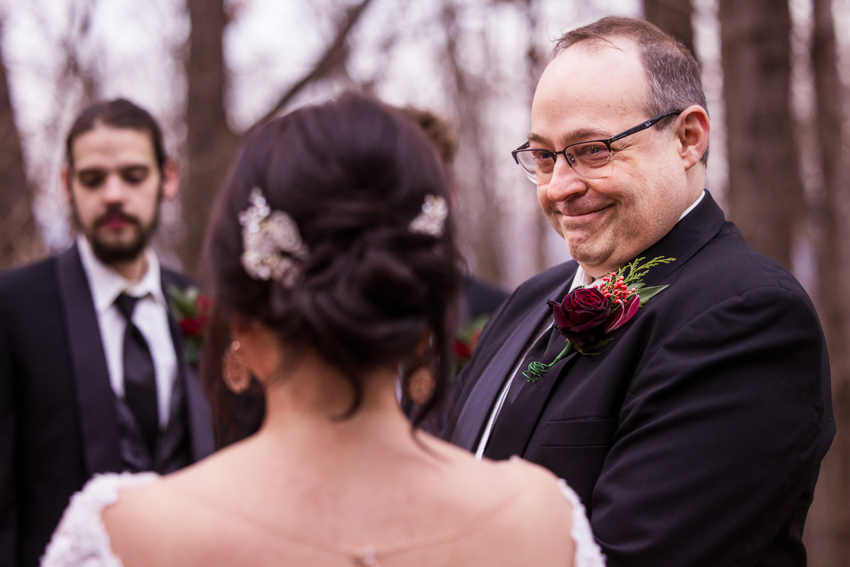 close up image of the groom as he smiles and beams at his bride during this outdoor wedding ceremony at auradell located at the stroudsmoor country inn in pa 