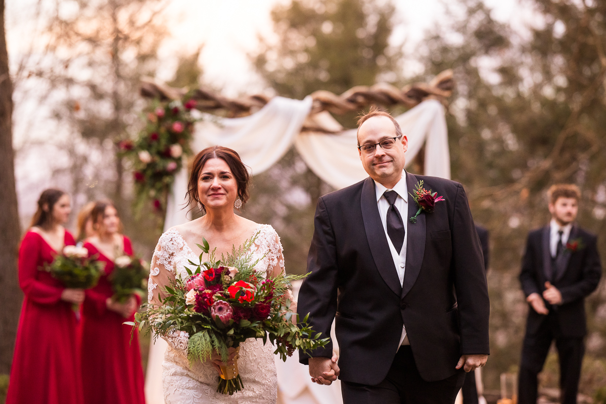 image of the bride and groom as they walk down the aisle at auradell in the stroudsmoor country inn at the end of their outdoor Christmas wedding ceremony 