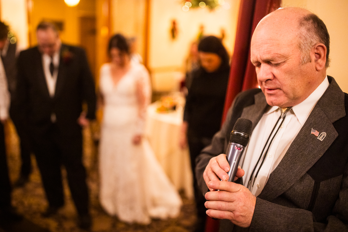 sentimental image of the bride's father as he prays during this stroudsmoor country inn wedding reception 