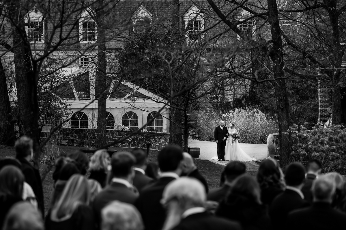 Stone mill inn wedding photographer, Lisa Rhinehart, captures this black and white image of the bride and her father as they prepare to walk down the aisle before this outdoor Christmas wedding ceremony 