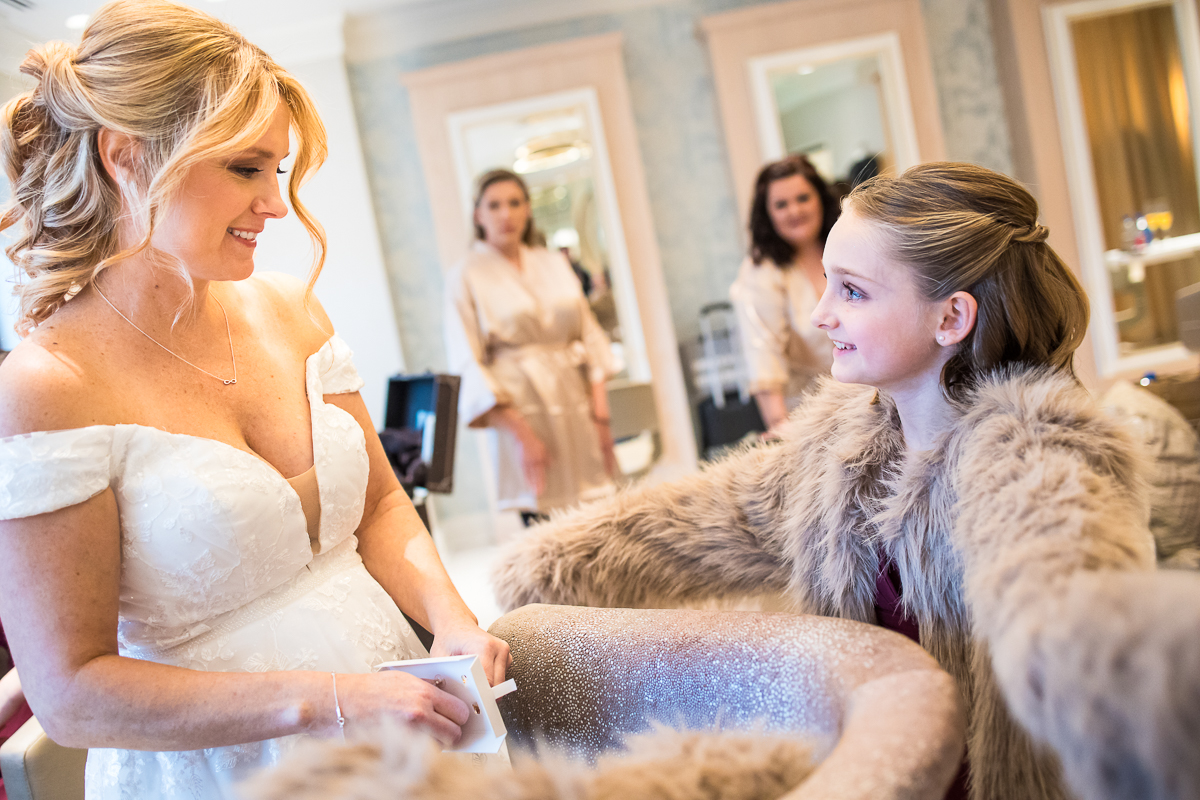 image of the bride as she smiles at her daughter after seeing her dressed up for the wedding during these wedding preparations at the reeds in New Jersey 