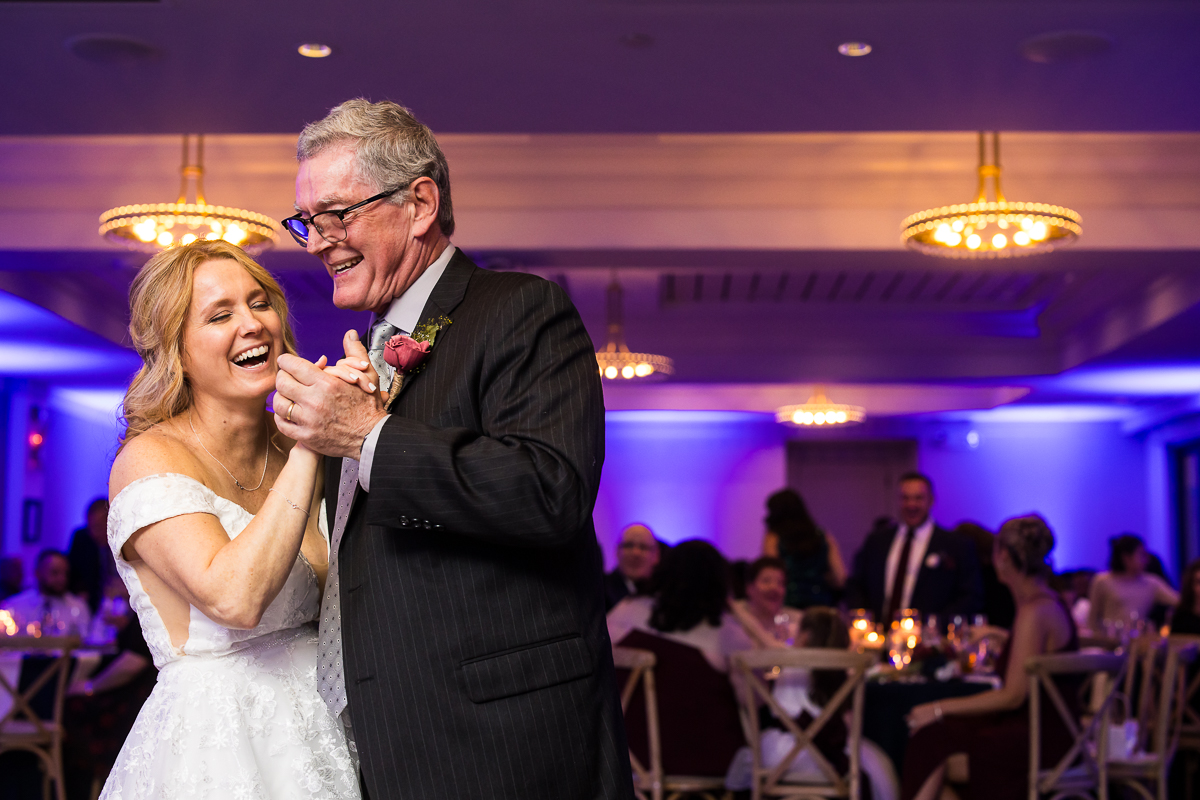 fun, vibrant, colorful image of the bride and her father as they dance together during their father daughter dance at this fun winter wedding reception in New Jersey 