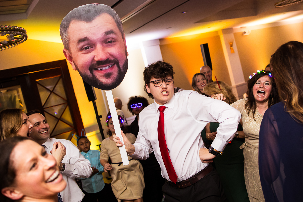 stone harbor wedding photographer, rhinehart photography, captures this fun image of guests as they dance with a fat head of the groom during this fun kid friendly wedding reception in New Jersey by the beach 