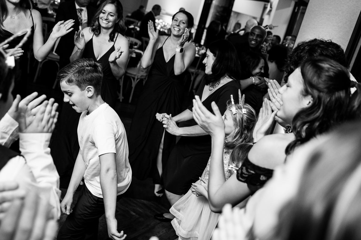 black and white image of the guests as they dance together with kids during this fun winter wedding reception at the reeds 