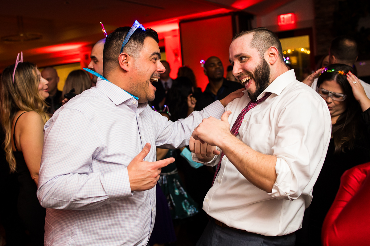 vibrant, colorful image of two male guests as they dance together during this fun kid friendly wedding reception in stone harbor New Jersey 