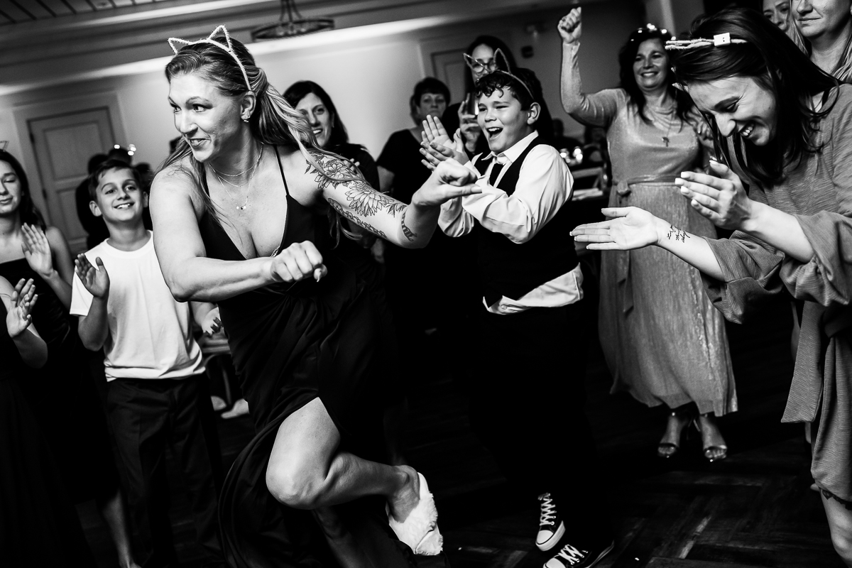 best wedding reception photographer, rhinehart photography, captures this fun black and white image of guests as they dance together and wear fun headbands during this kid friendly Winter Reeds Stone Harbor Wedding reception 