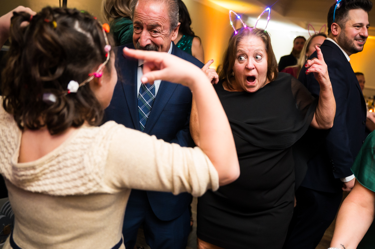 best nj wedding reception photographer, rhinehart photography, captures this fun, colorful image of guests as they dance with kids during this fun kid friendly wedding reception in stone harbor New Jersey 