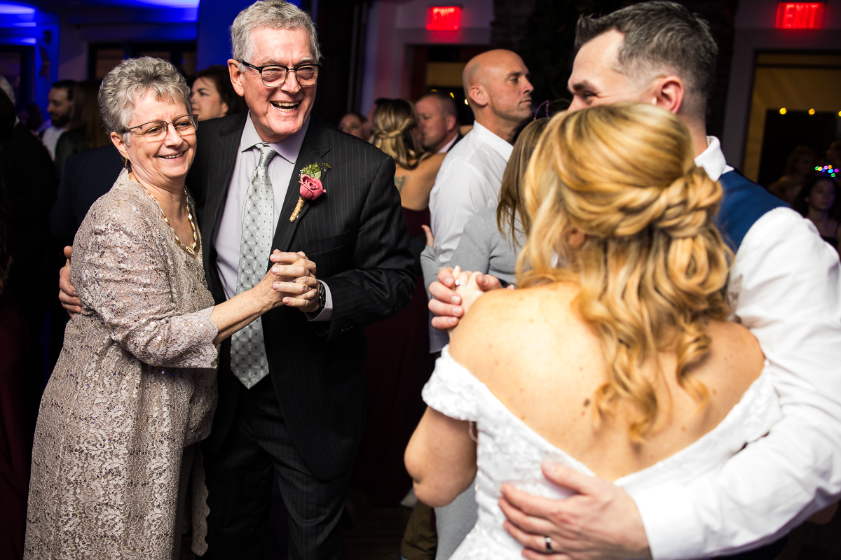wedding reception photographer, rhinehart photography, captures this vibrant, colorful image of the bride and groom as they dance together with other guests during this fun, kid friendly wedding reception at the reeds 