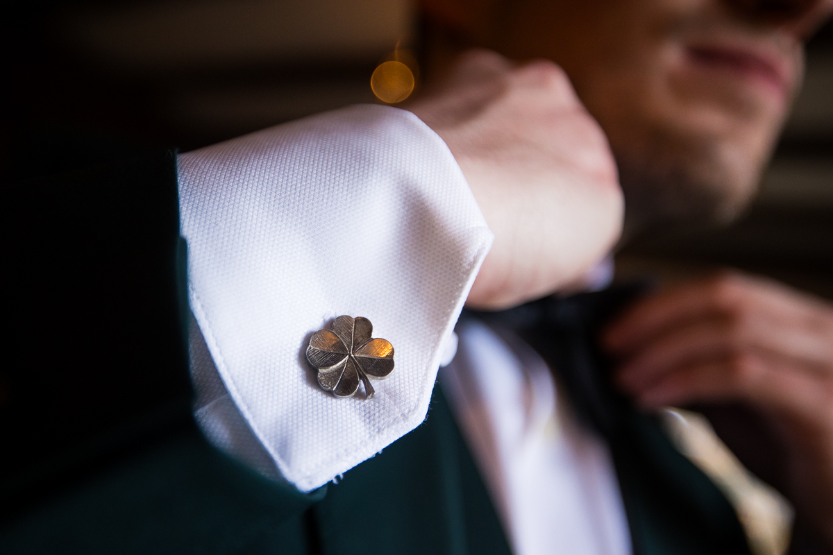 close up image of the groom's shamrock cufflinks, a nod to his Irish heritage