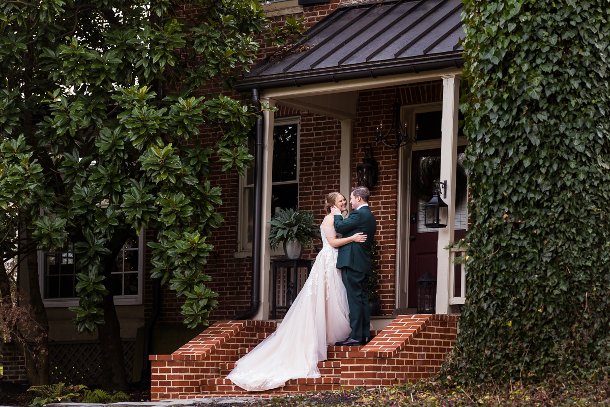 Stone Mill Inn Wedding photographer, Lisa Rhinehart, captures the first look between the bride and groom as they see each other for the first time on the steps of the house before this outdoor Christmas wedding ceremony in Hallam pa 