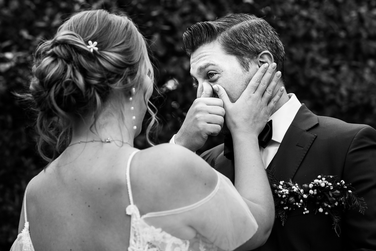 Stone Mill Inn Wedding photographer, Lisa Rhinehart, captures this candid, authentic moment of the groom as sheds a tear and he and the bride wipe his tear away during the couple's first look in Hallam pa 
