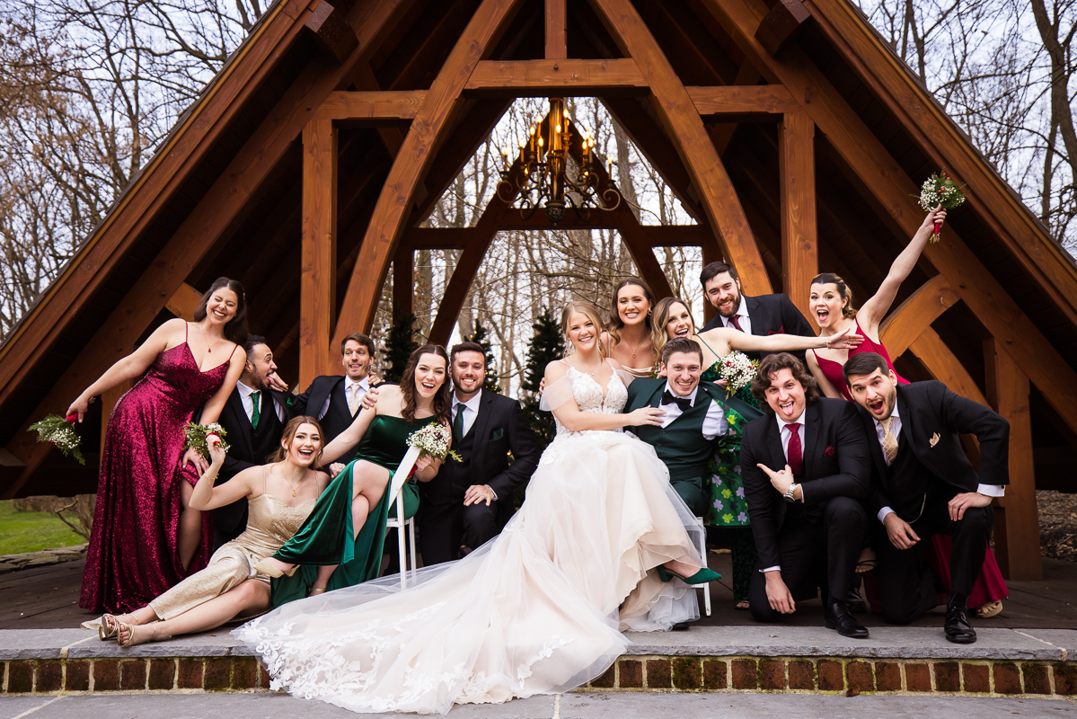 creative wedding photographer, Lisa Rhinehart, captures this fun, outdoor shot of the wedding party as they make funny faces, laugh, smile, etc in front of the abbey before this outdoor winter wedding 