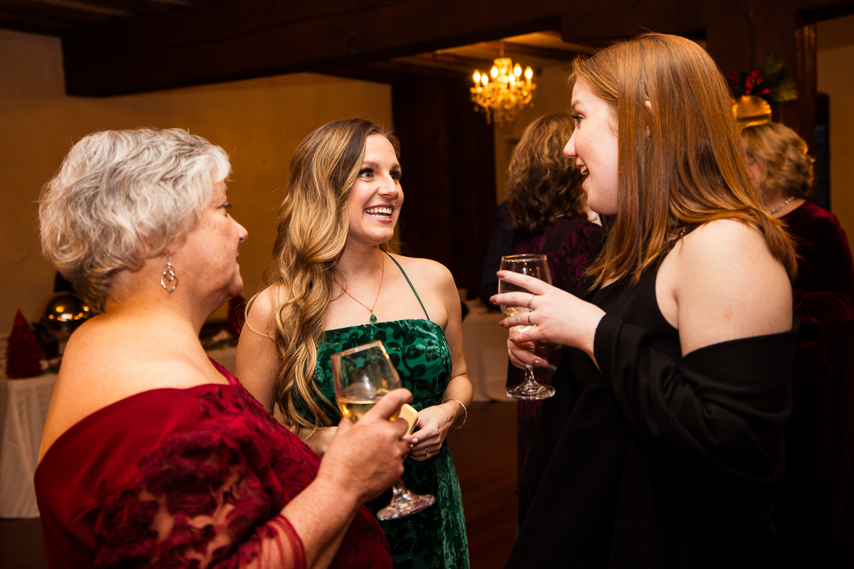 candid image of guests as they hang out and talk with each other during this stone mill inn cocktail hour after this winter wedding ceremony 