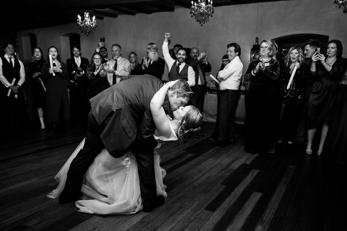 black and white image of the bride and groom as they dip and share a kiss together after their choreographed first dance at this Christmas wedding reception captured by best pa wedding photographer, Lisa Rhinehart 
