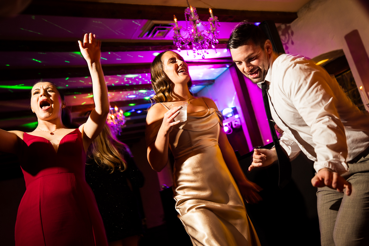 candid wedding photographer, Lisa Rhinehart, captures this image of guests as they dance and sing together during this Christmas wedding reception 