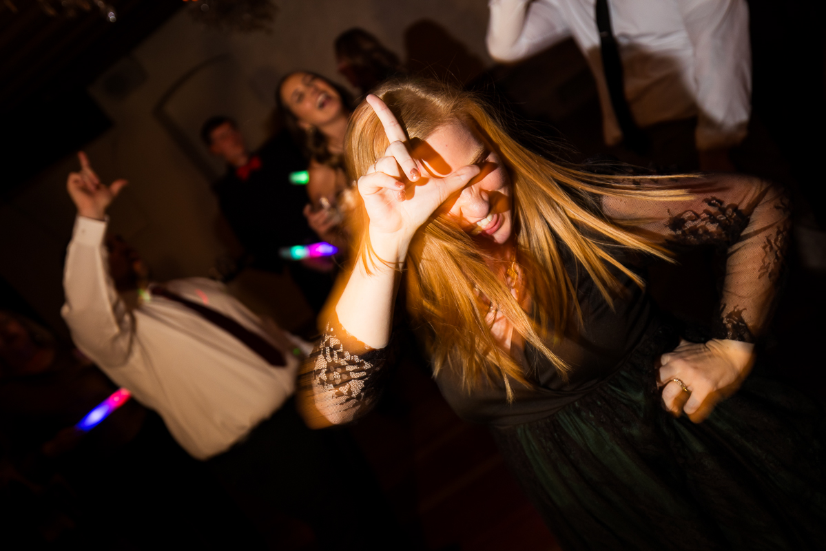 best pa wedding photographer, Lisa Rhinehart, captures this image of a guest as she dances and places an L on her forehead at someone during this fun, crazy winter wedding reception in Hallam pa 