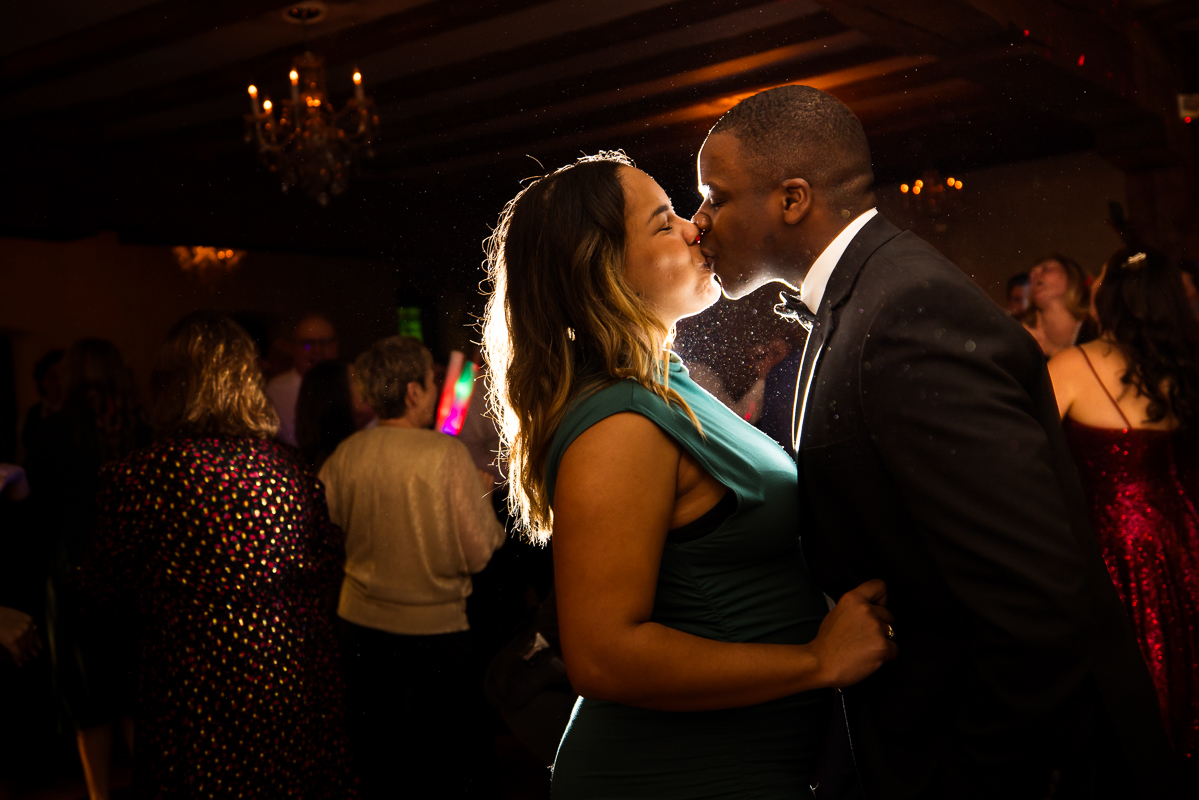 Stone Mill Inn Wedding photographer, Lisa Rhinehart, captures this image of guests as they share a kiss on the dance floor at this winter wedding reception in Hallam pa 