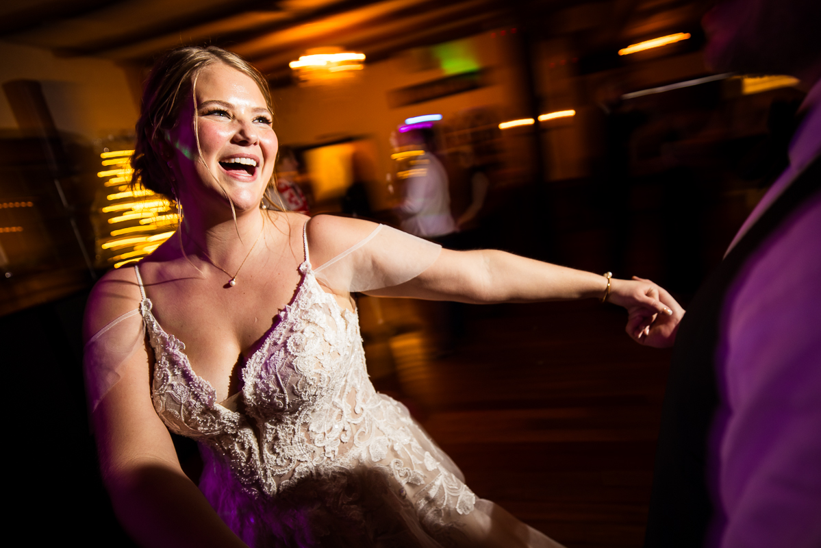 candid image of the bride as she spins arounds while dancing during her winter wedding reception captured by best pa wedding photographer, Lisa Rhinehart 
