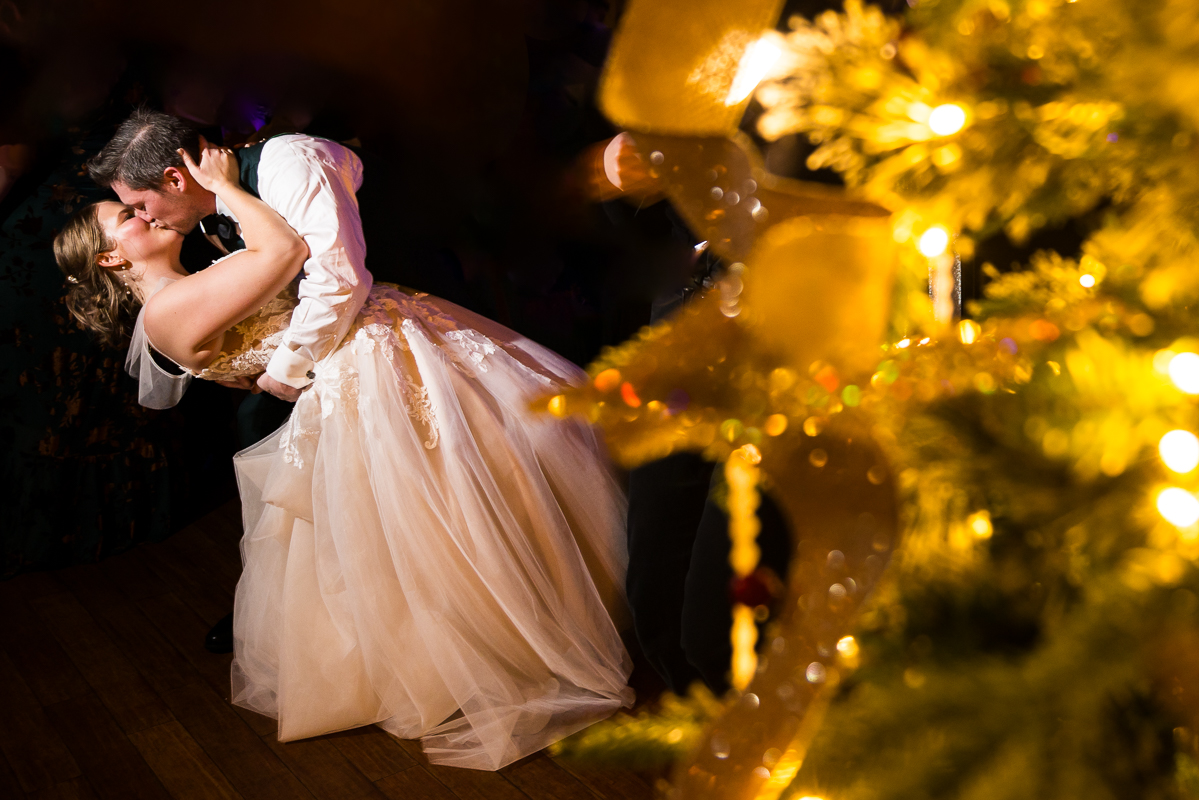creative pa wedding photographer, Lisa Rhinehart, captures this image of the bride and groom as they share a kiss at the end of their private last dance before they conclude their stone mill inn Christmas wedding reception in Hallam pa 