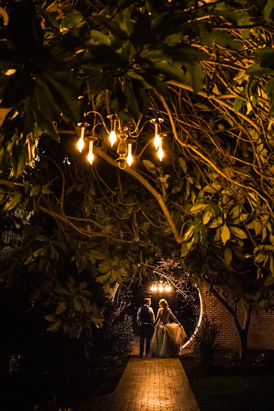 creative pa wedding photographer, Lisa Rhinehart, captures this image of the bride and groom as they stand under the moon gate at stone mill inn for their end of the night shots 