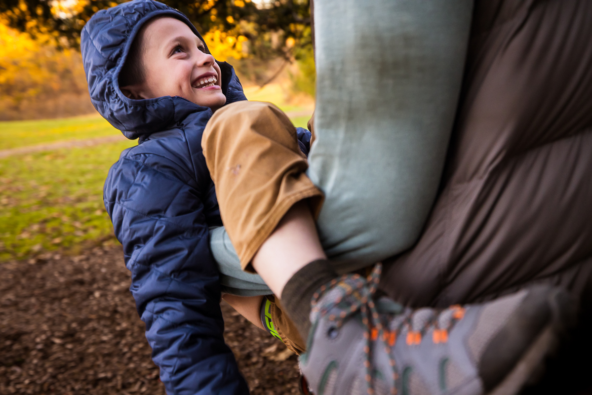 candid pa family photographer, Lisa Rhinehart, captures this fun, candid image of the dad and his son as they play together during this outdoor family session at the wildlands conservancy in emmaus pa 