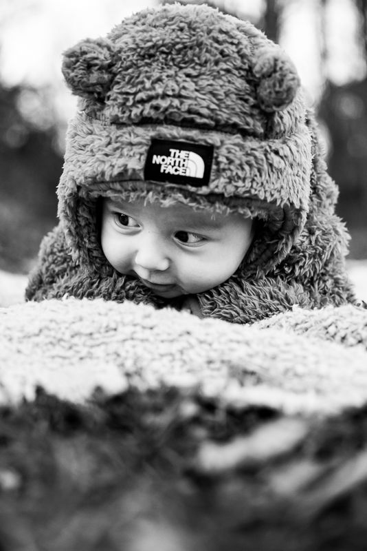 black and white close up image of the baby as he crawls on the picnic blanket during this outdoor fall family session in pa 
