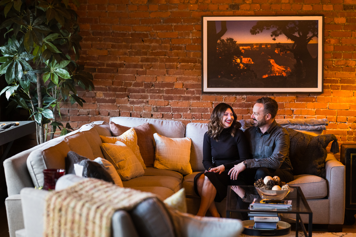 pa engagement photographer, Lisa Rhinehart,captures this fun, candid image of the couple as they sit together on their couch inside of their York PA apartment building during their engagement session 