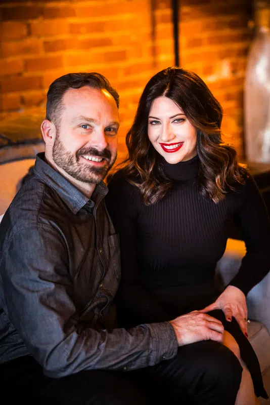 traditional portrait of the couple who are typically camera shy and not photogenic as they pose together during their engagement session inside of their York PA apartment