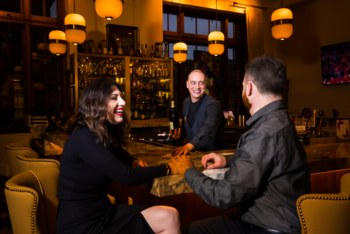 image of the couple as they share a laugh together with staff at the bar inside of the Yorktowne hotel in pa 