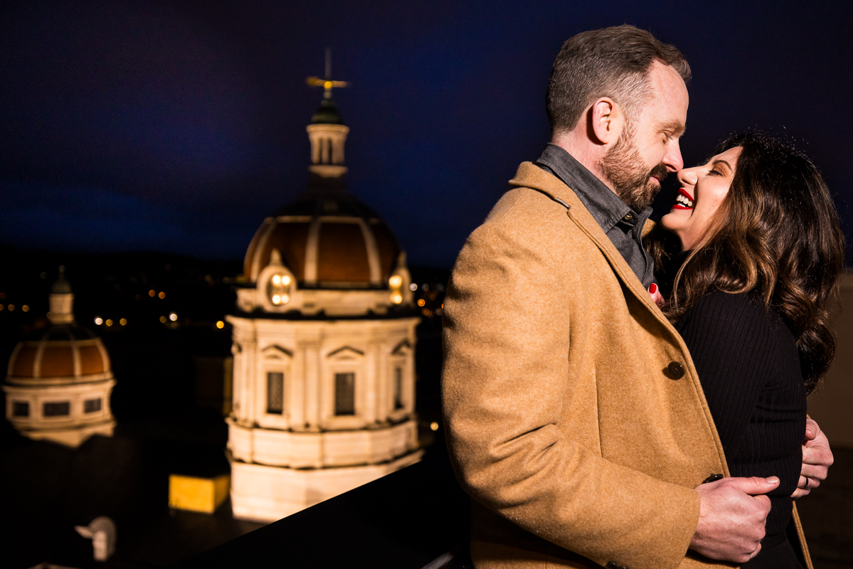 Yorktowne Hotel Wedding engagement photographer, Lisa Rhinehart, captures this image of the couple as they share a laugh on the roof top of this York pa hotel for this outdoor, winter engagement session 