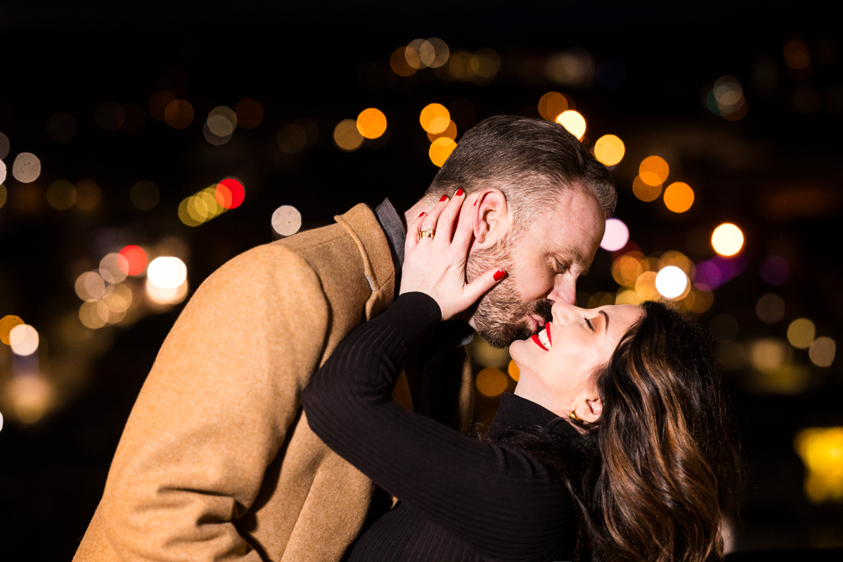 Yorktowne Hotel Wedding engagement photographer, Lisa Rhinehart, captures this fun, candid, creative image of the couple as they share a kiss during this night time romantic portrait captured in York pa during this engagement session 