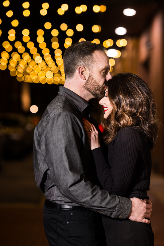 traditional portrait of the couple as they share a kiss on the forehead during this outdoor winter engagement session in york pa 